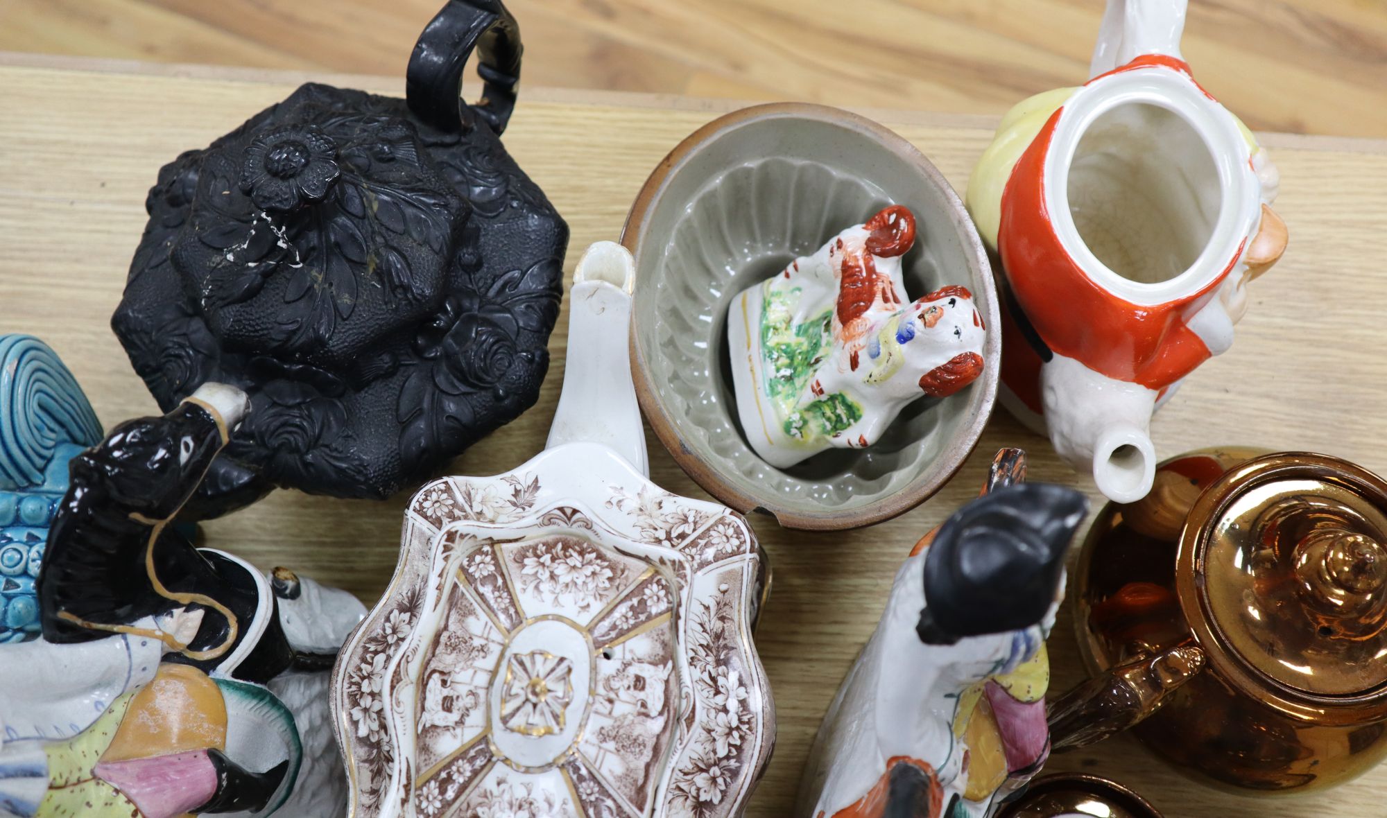 A group of Staffordshire pottery figures, teapots and lustre wares
